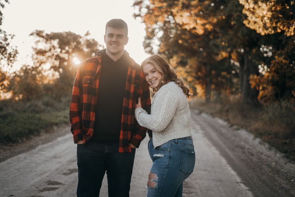 A couple walks together at sunset on a rural path.