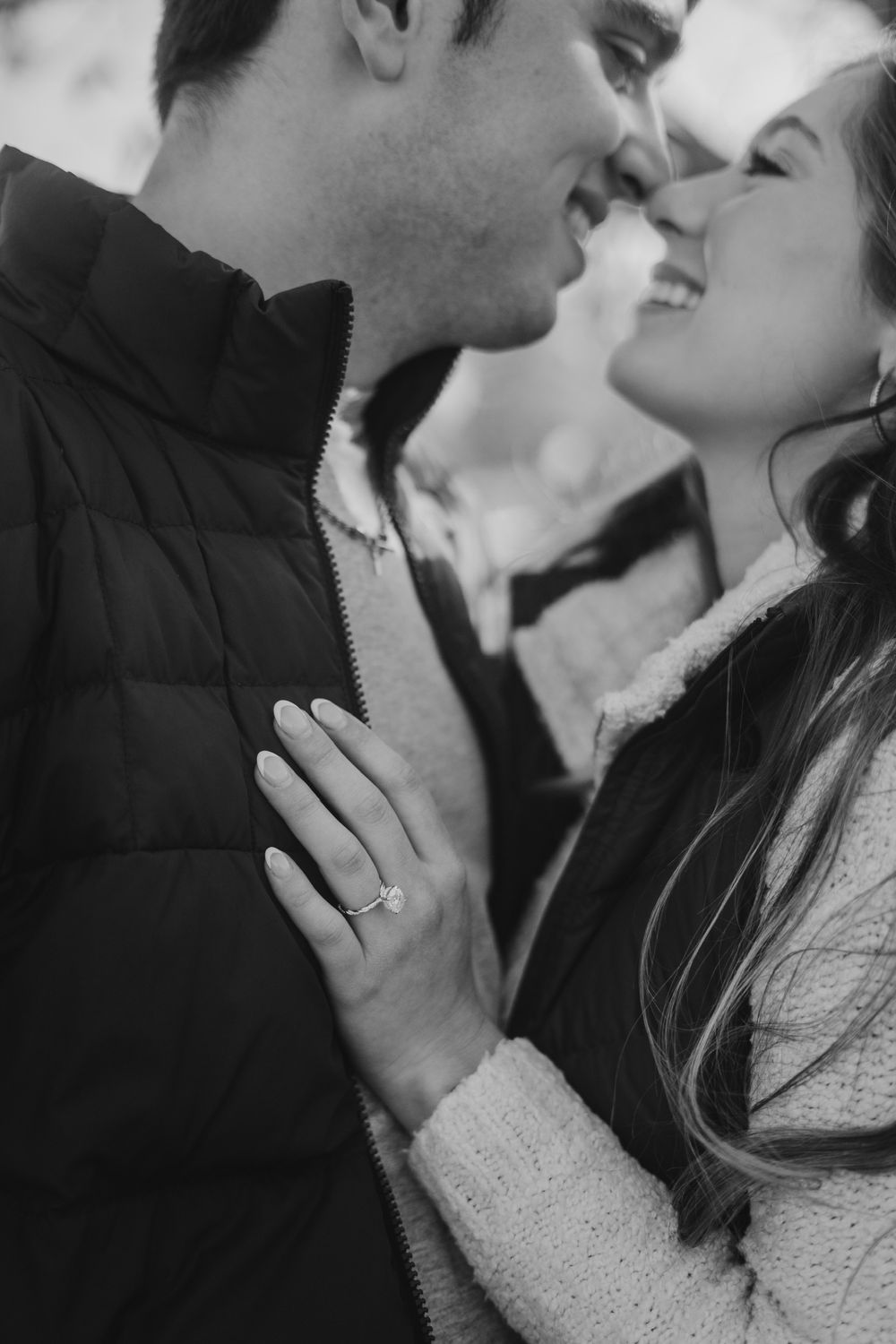 Black and white intimate portrait of a couple in winter clothing.