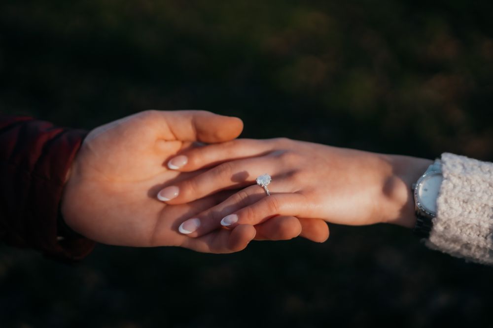 Close-up shot of hands tenderly touching in natural lighting.