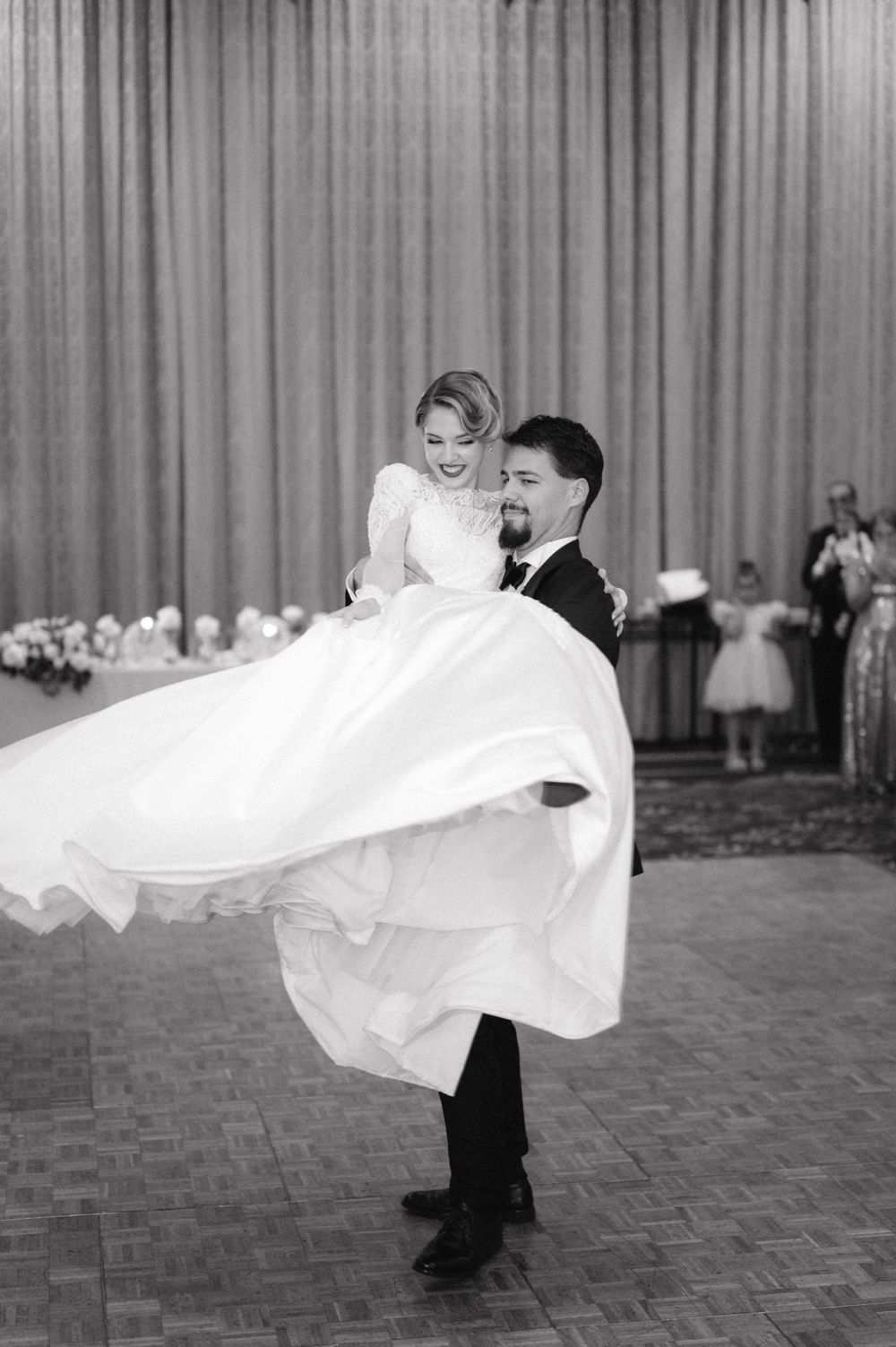 A romantic black and white dance photo with the bride's dress elegantly swirling.