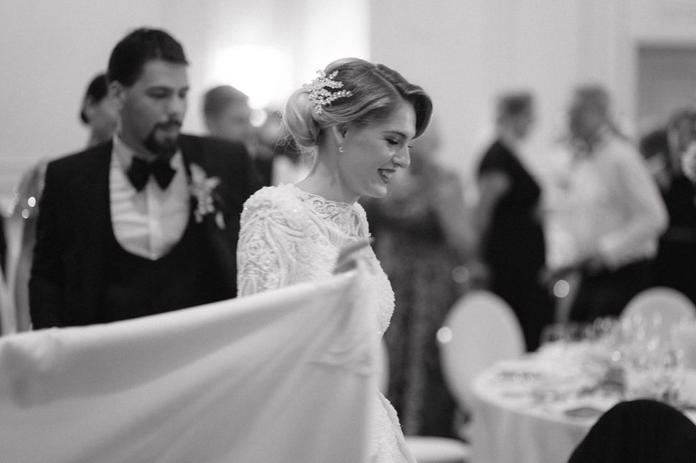 A bride in a white gown gracefully moves across the dance floor at her wedding reception.