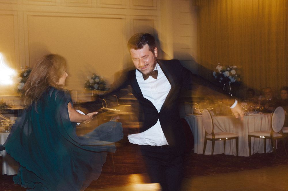 Energetic dance moves captured in motion blur at an elegant reception.