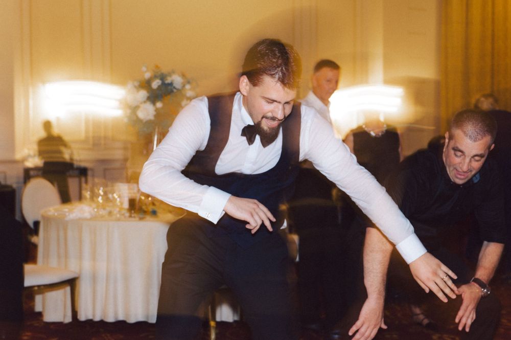 Dancer performs enthusiastic moves at wedding reception.