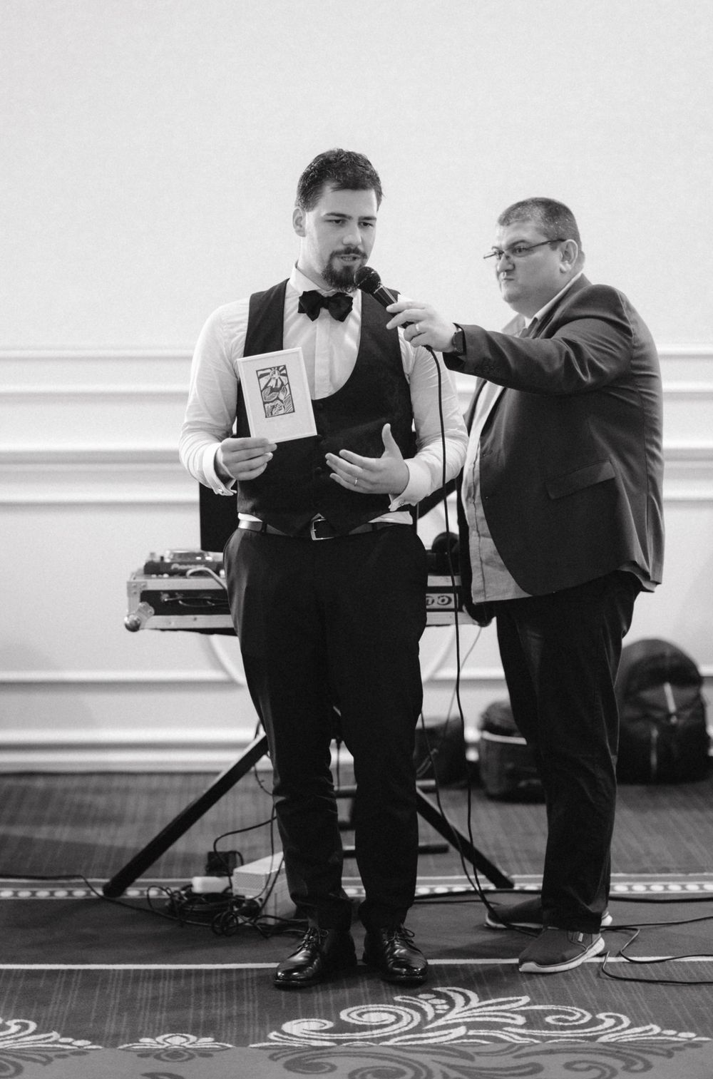Two performers on stage with microphones during formal event.