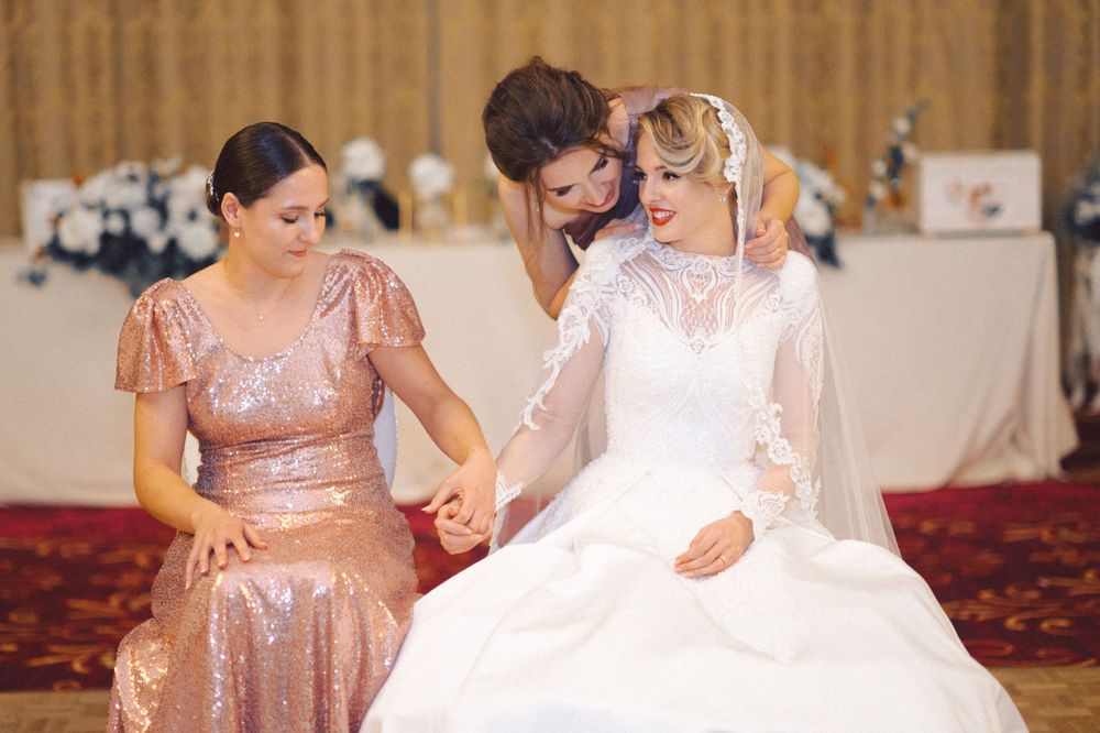 Wedding party getting ready in luxurious room with rose gold bridesmaid dresses.