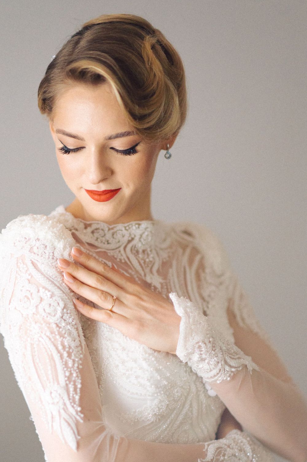 Classic bridal portrait showcasing delicate lace sleeves and vintage-inspired hair and makeup.