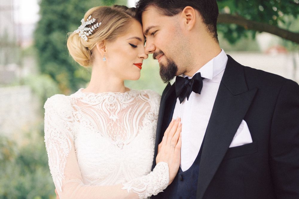 Romantic wedding portrait showing tender moment between newlyweds in vintage-inspired attire.
