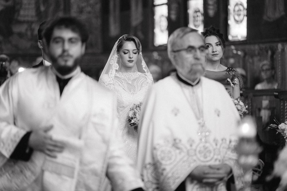 Black and white photograph of clergy procession during Orthodox wedding ceremony.