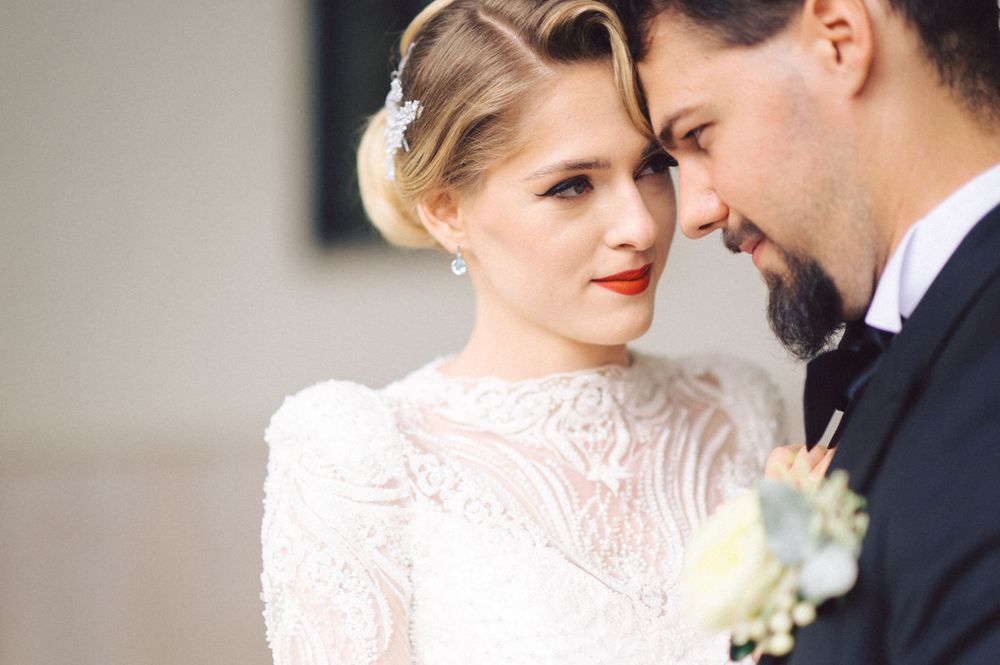 Elegant wedding portrait capturing intimate moment between couple with vintage-inspired styling.