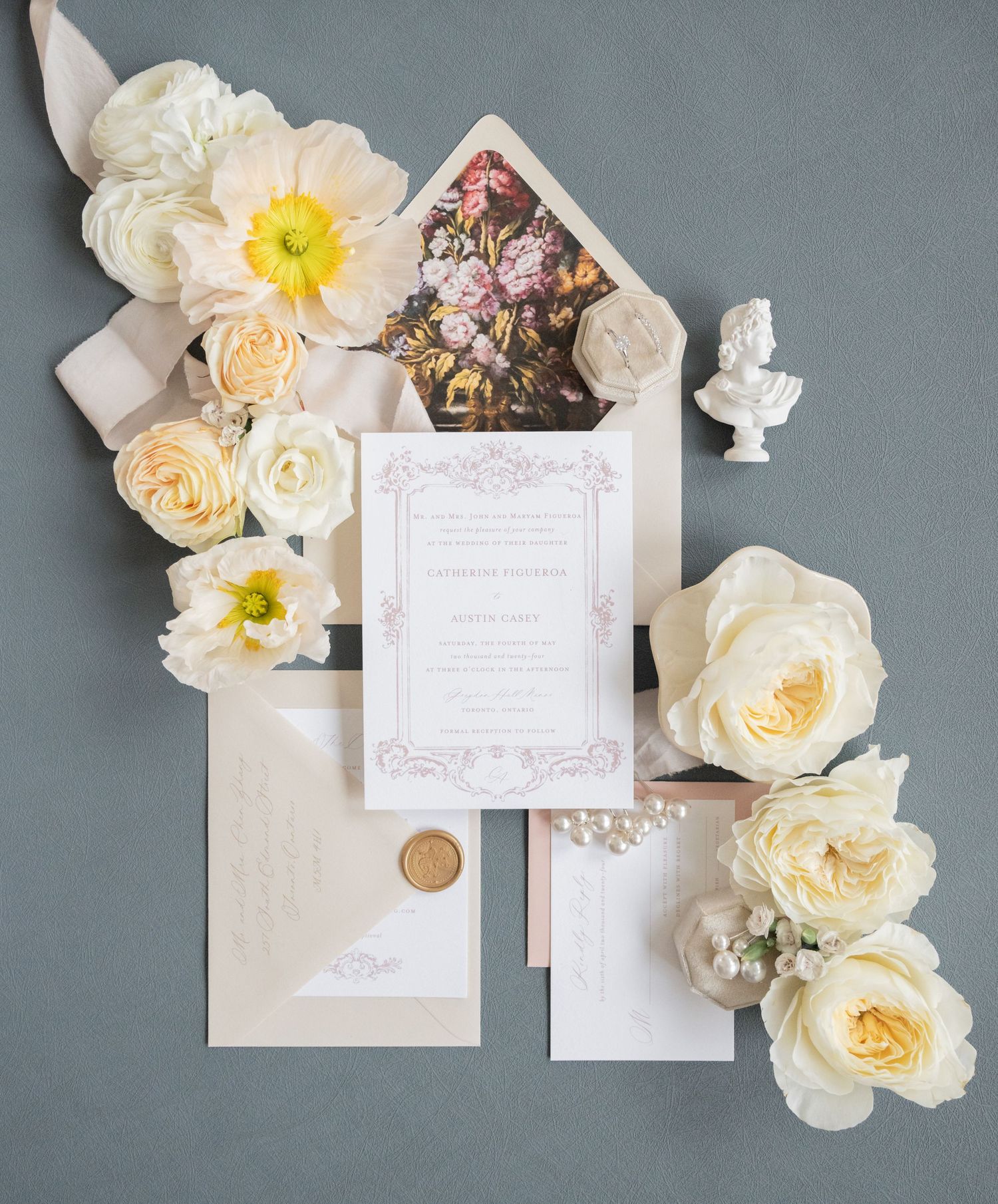 Elegant wedding invitation suite with cream roses and yellow daffodils on gray background.