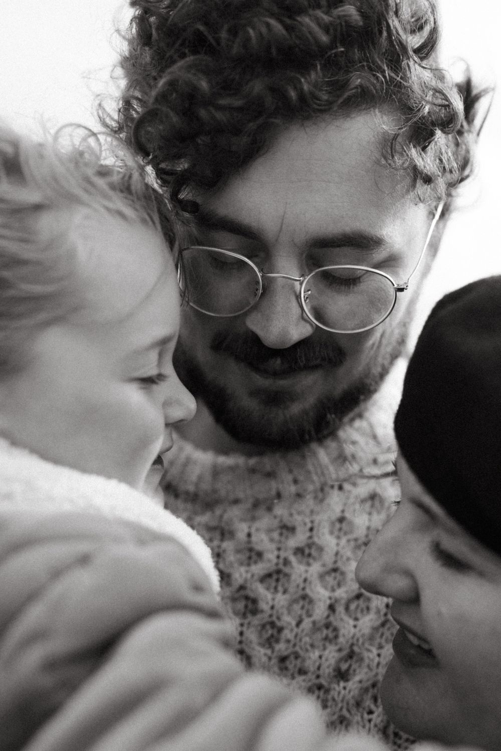 Black and white intimate family moment capturing warm smiles and togetherness.