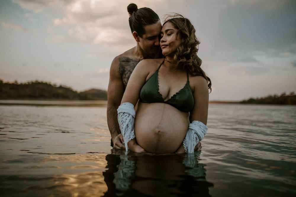 Couple in the water at Lake Moondarra, Mount Isa embracing baby bump