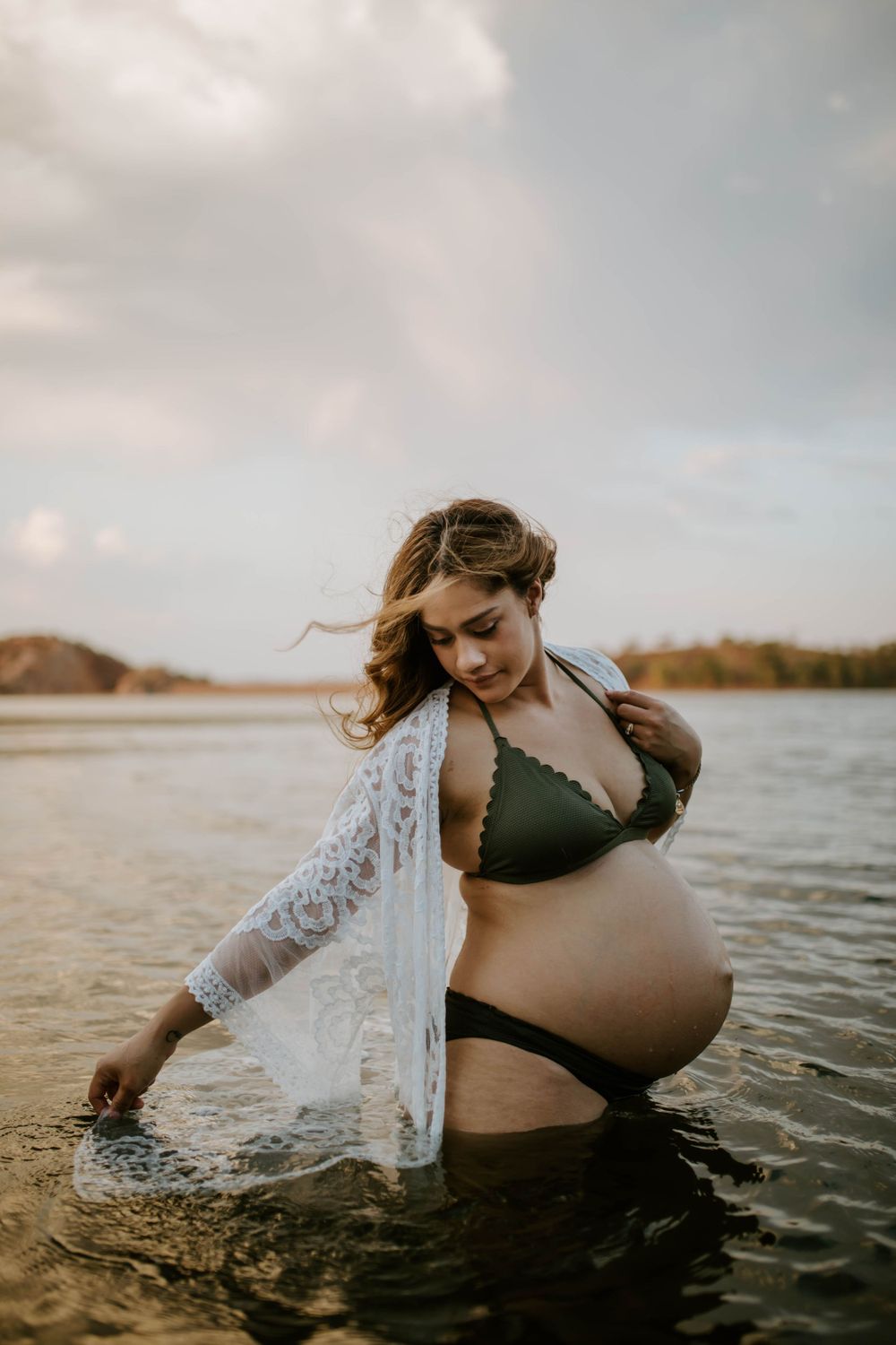 Mama to be standing in the water at Lake Moondarra embracing warm water