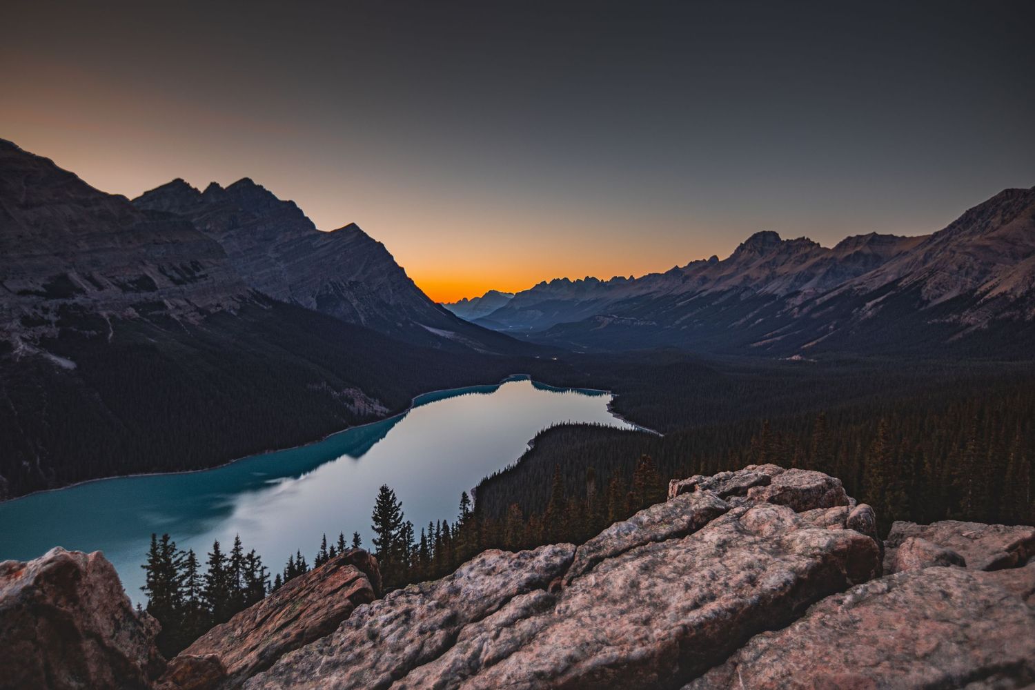 Peyto Lake in Banff National Park at sunset with mountain peaks and turquoise waters.