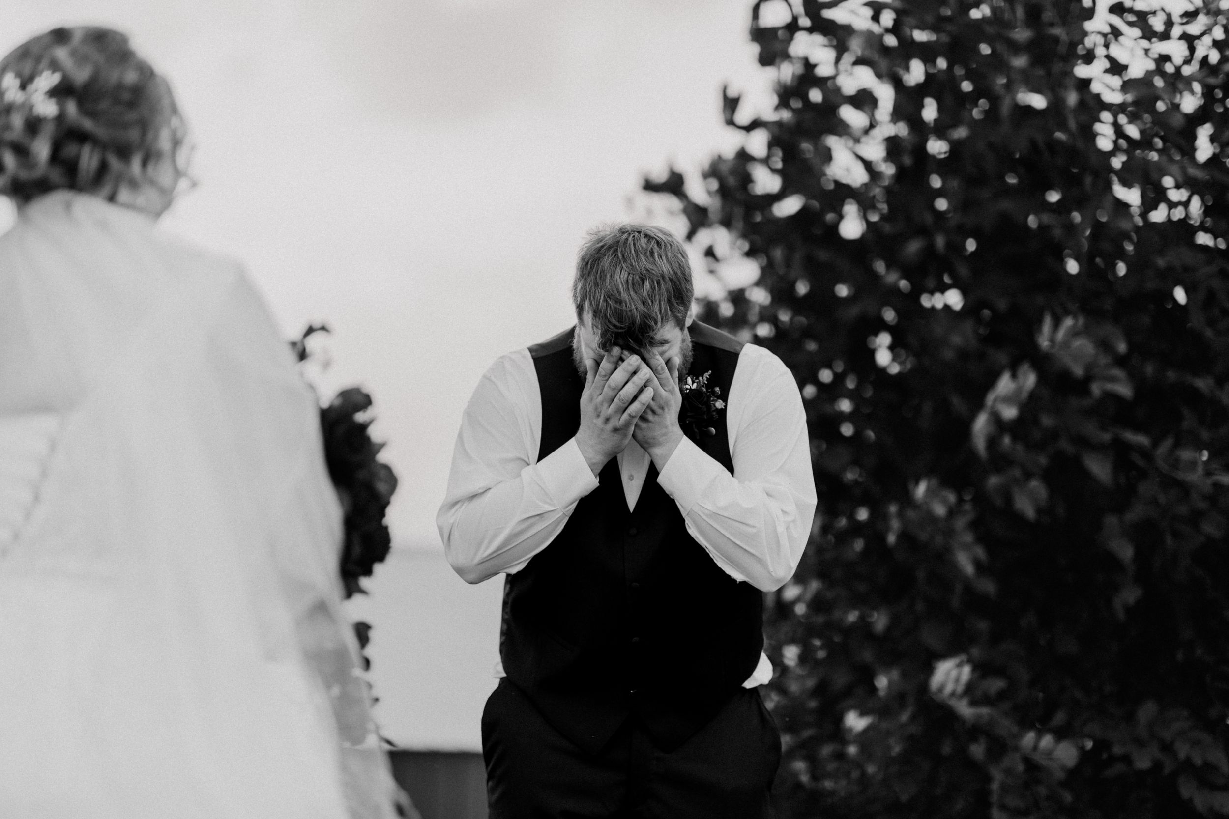 Emotional black and white wedding moment captured outdoors.