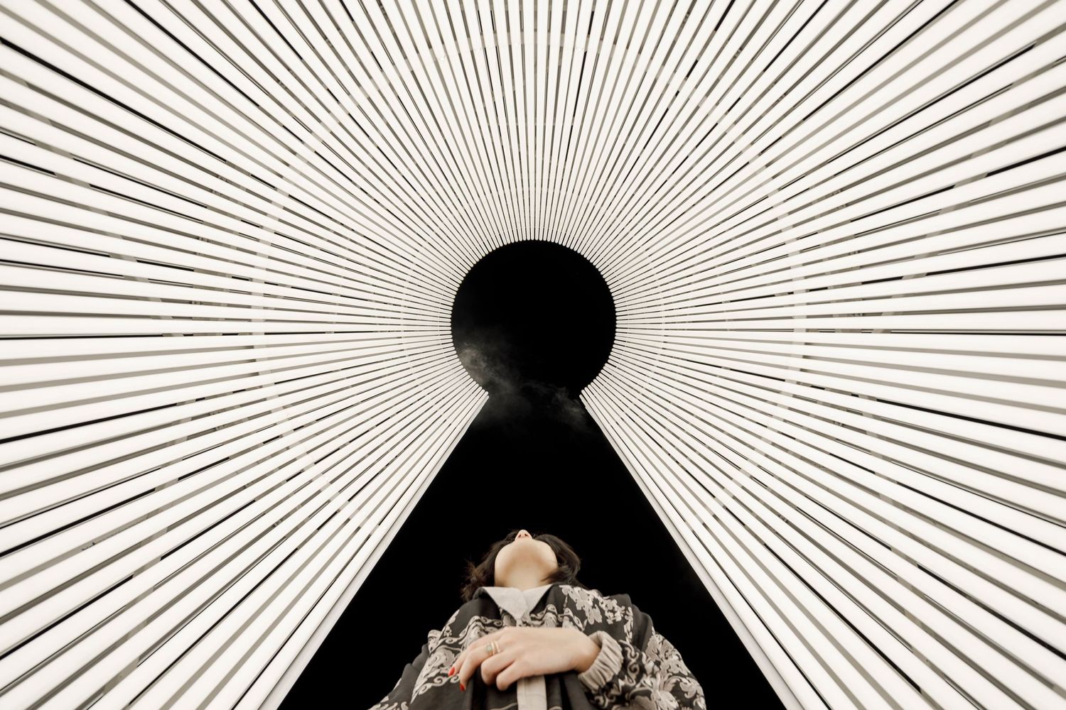 Geometric black and white starburst pattern with a dark keyhole shape in the center.