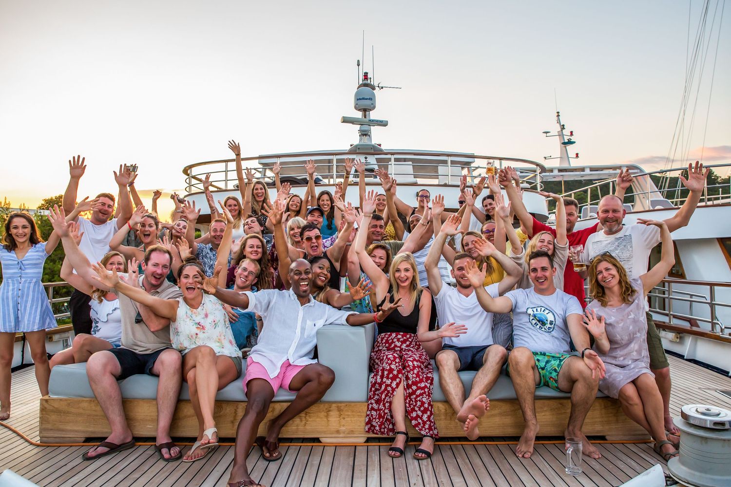 Group of people on boat with hands in the air