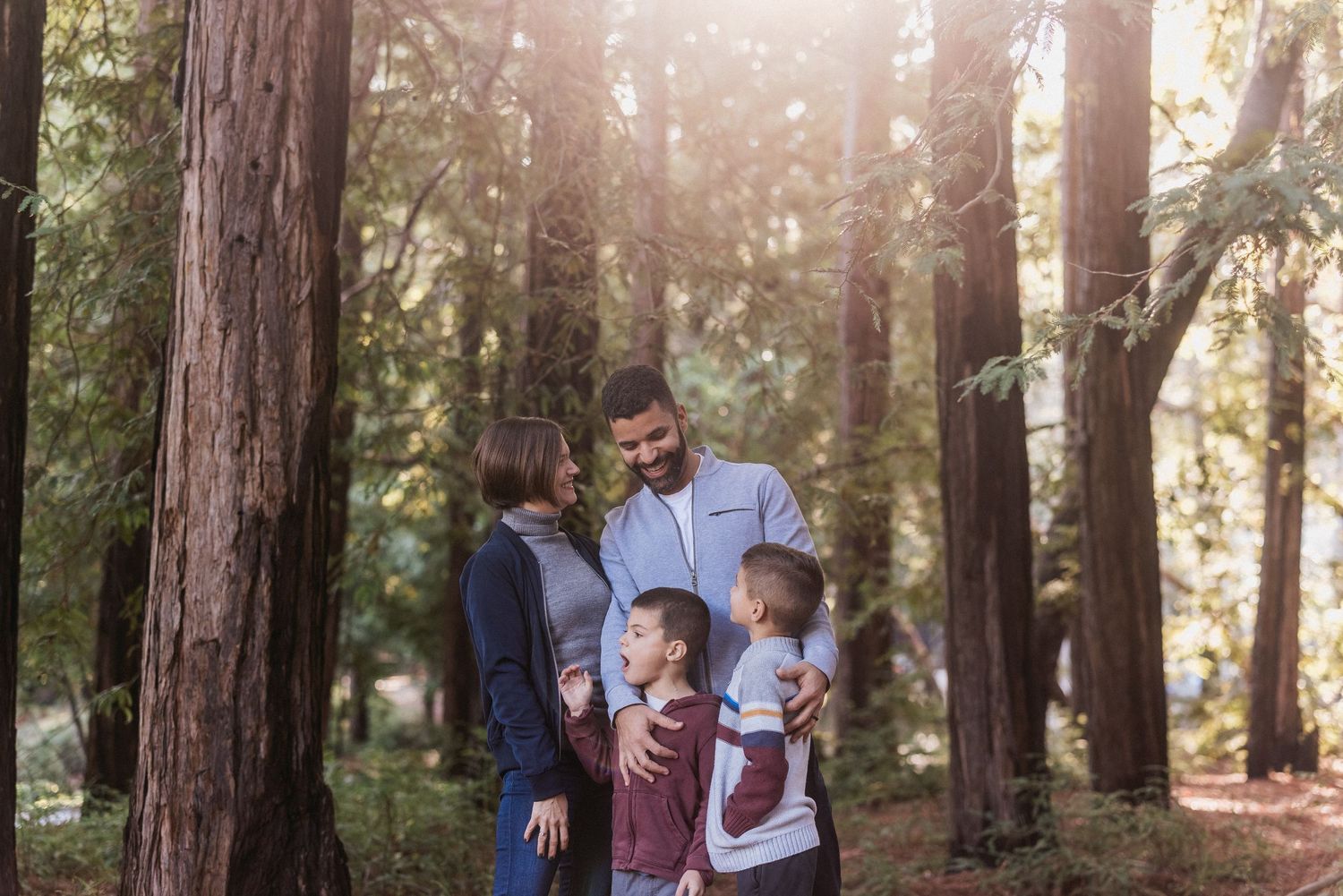 A family enjoying quality time together in a serene redwood forest.