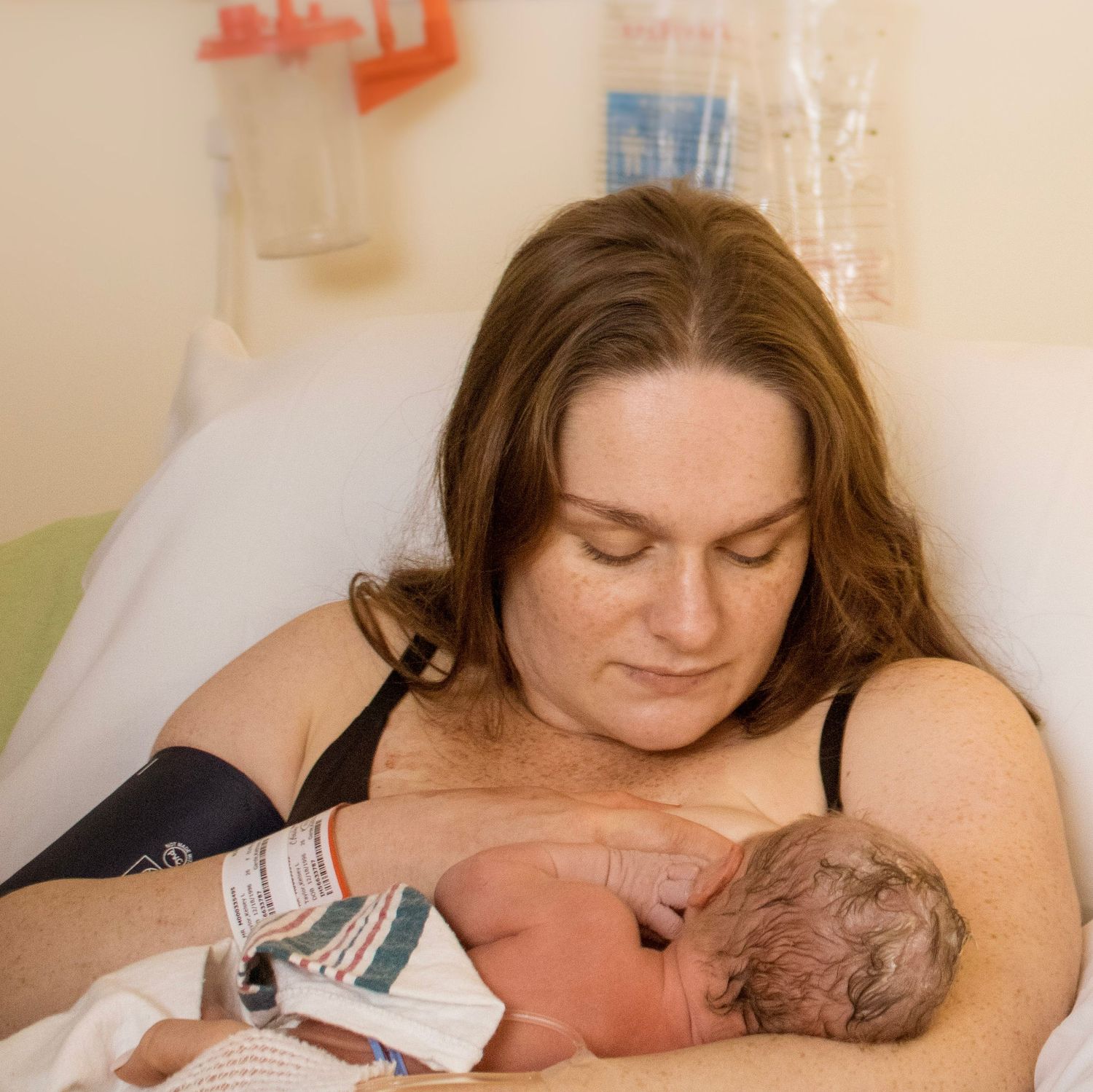 A tender first moments between mother and newborn in a hospital setting.