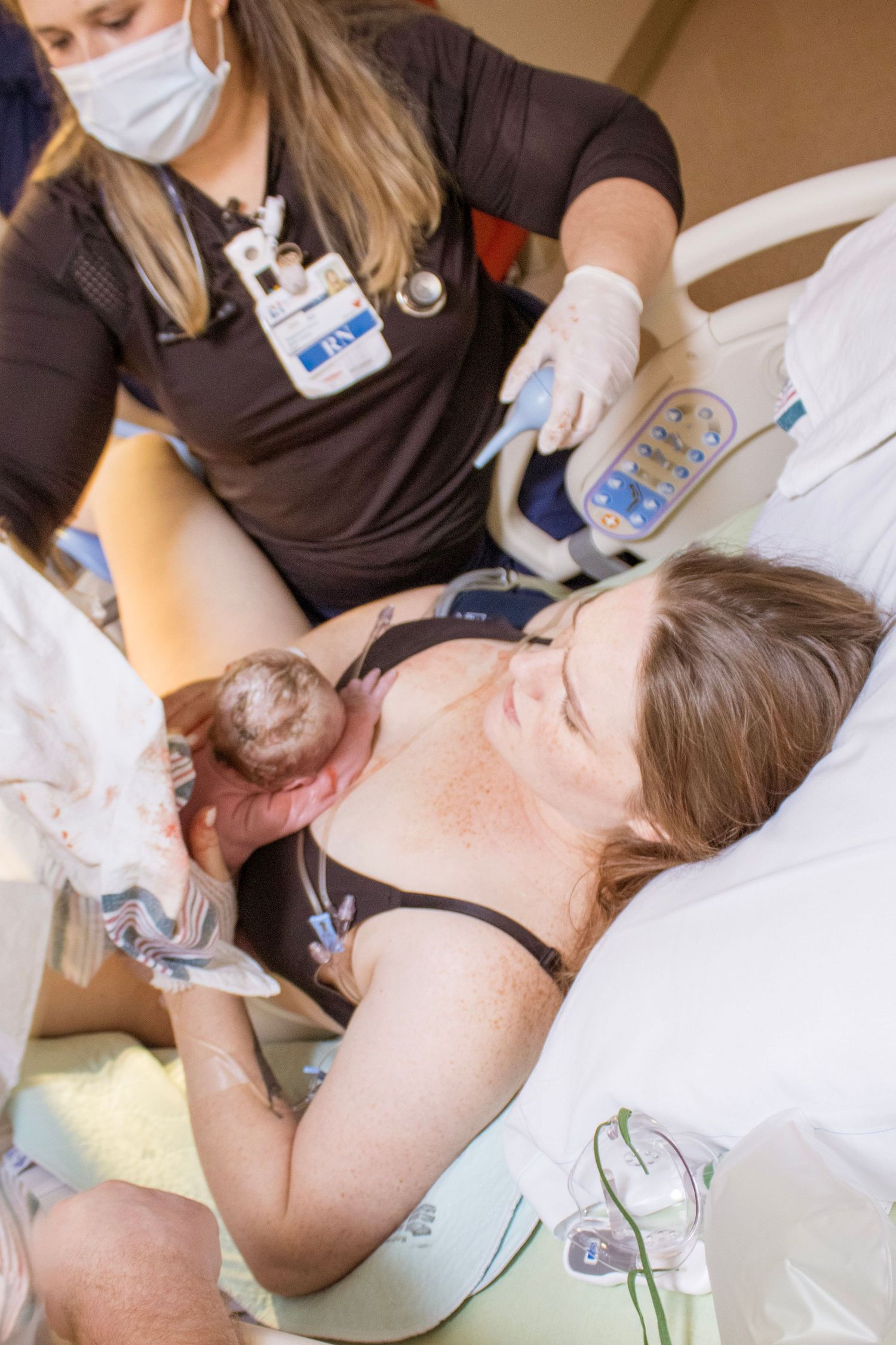Healthcare worker assists during childbirth in hospital delivery room.