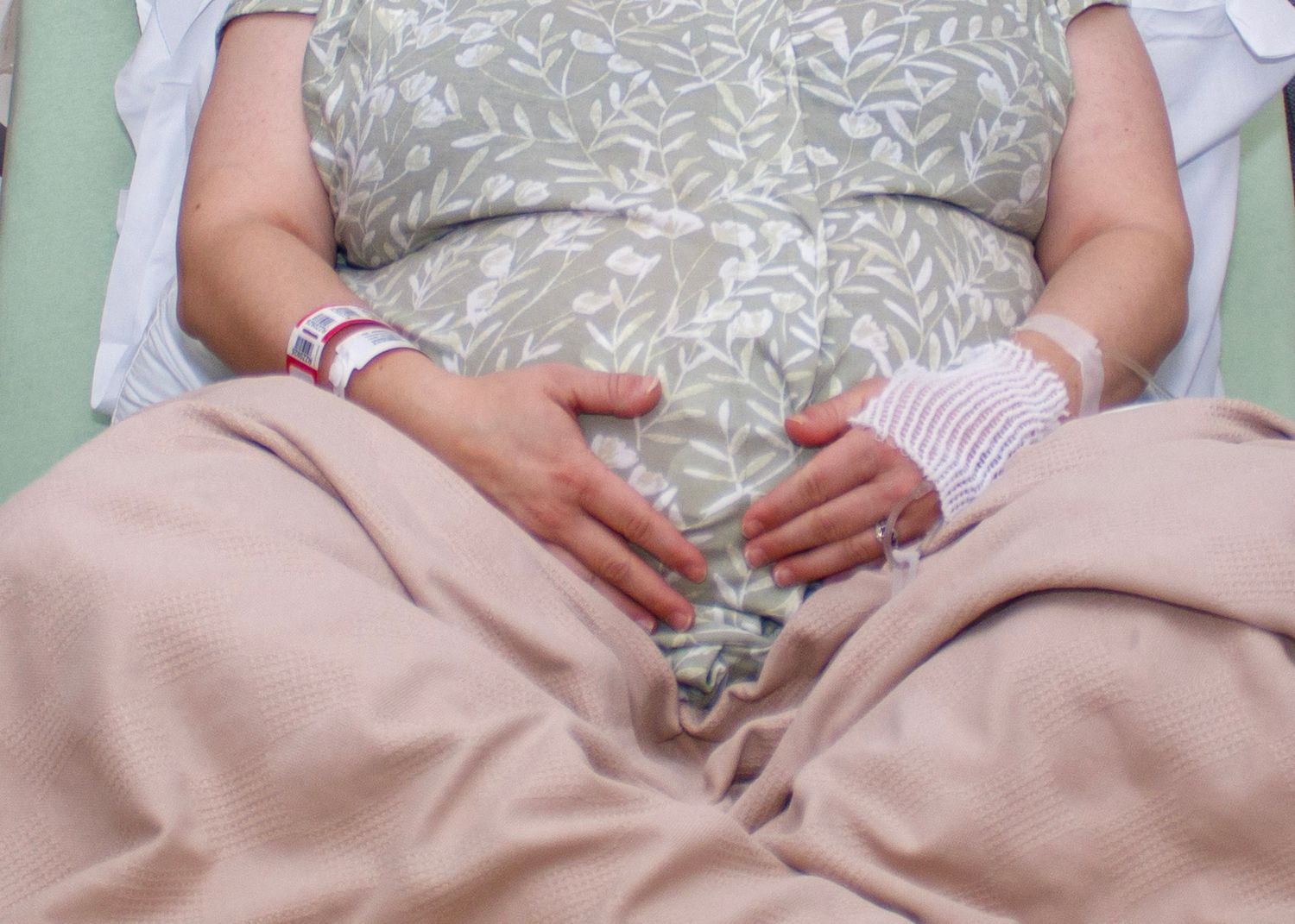 Patient resting in hospital bed with medical identification bracelet.