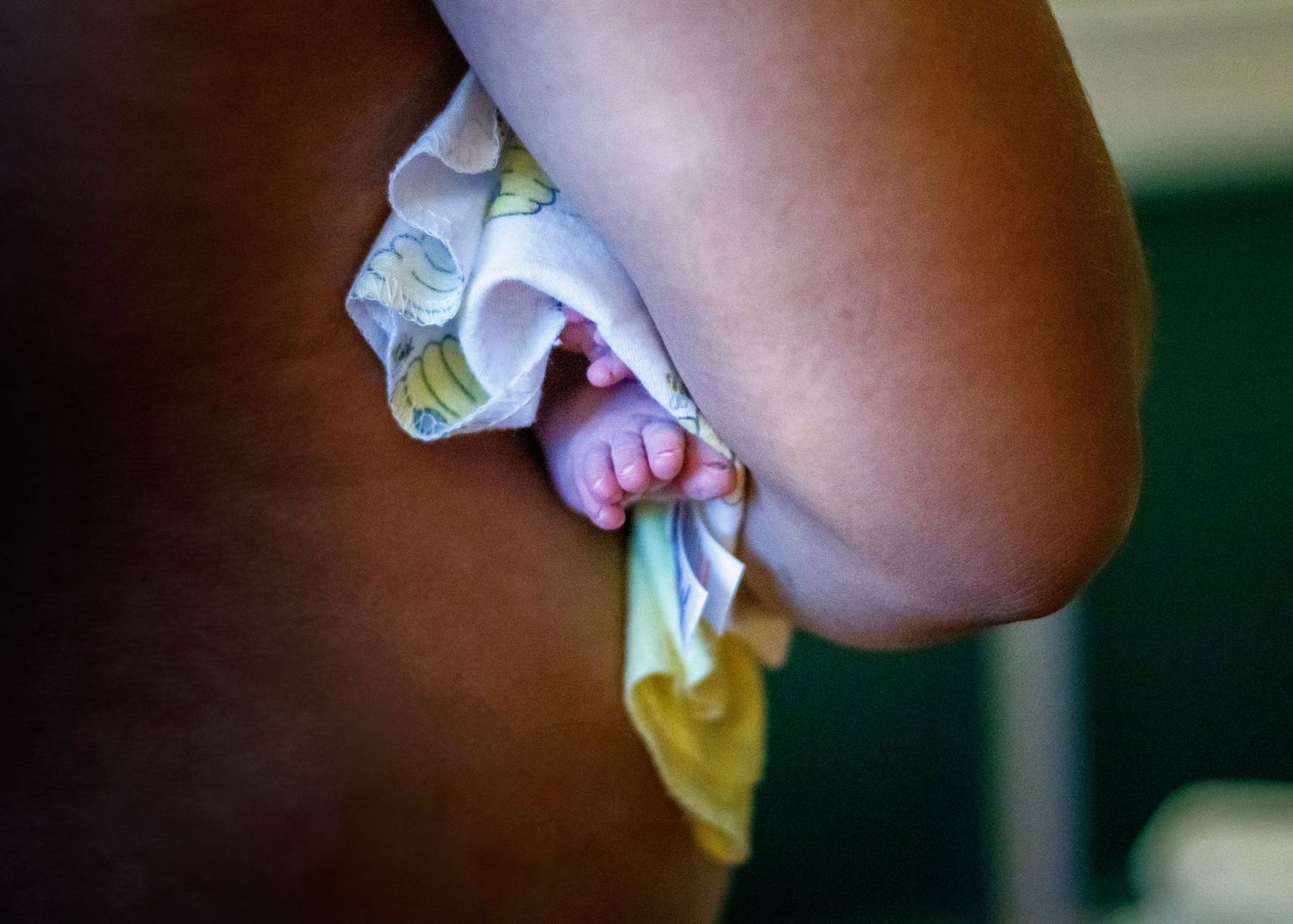 Close-up shot of infant wearing diaper against dark background.