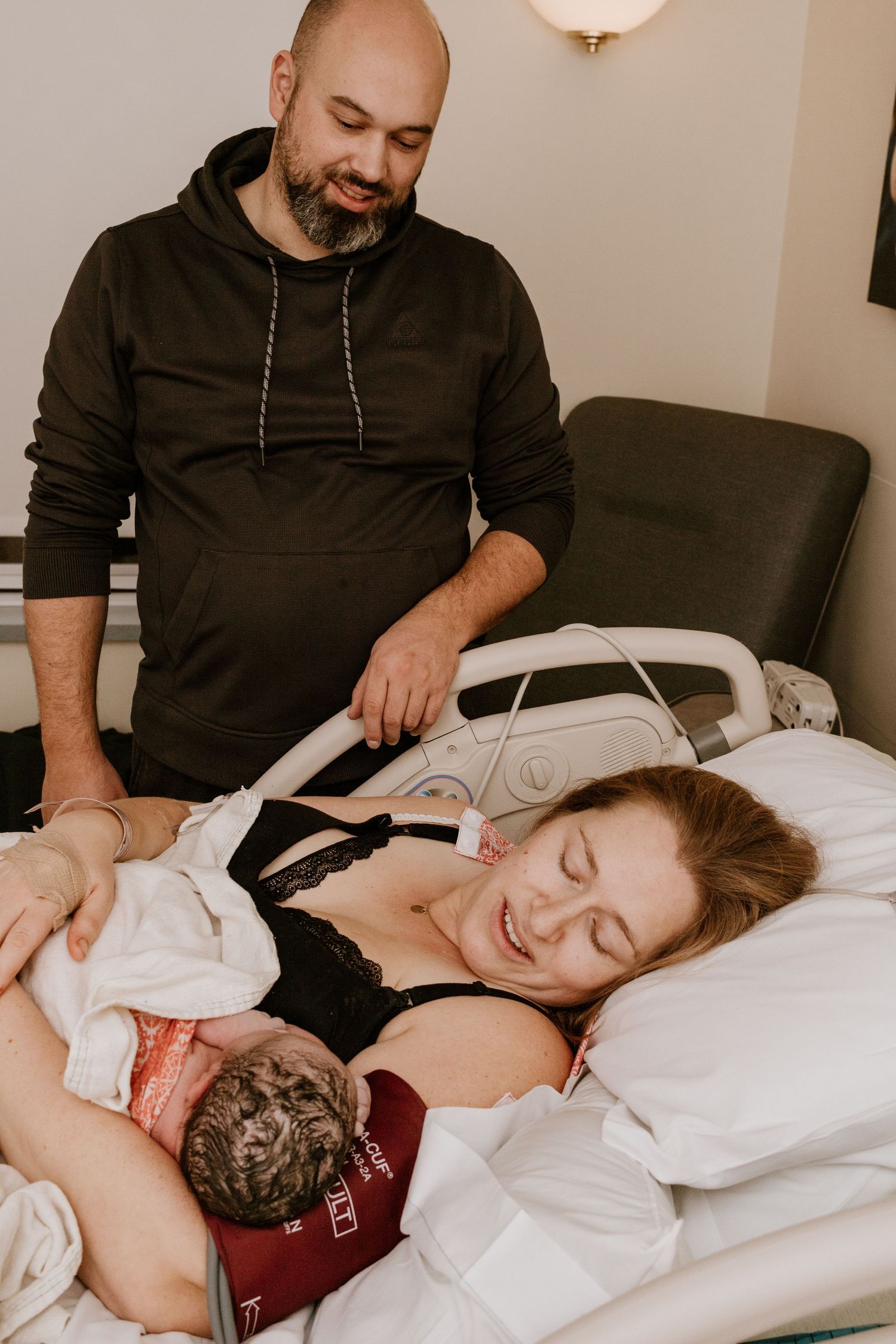 Tender moment in hospital room after childbirth with newborn baby.
