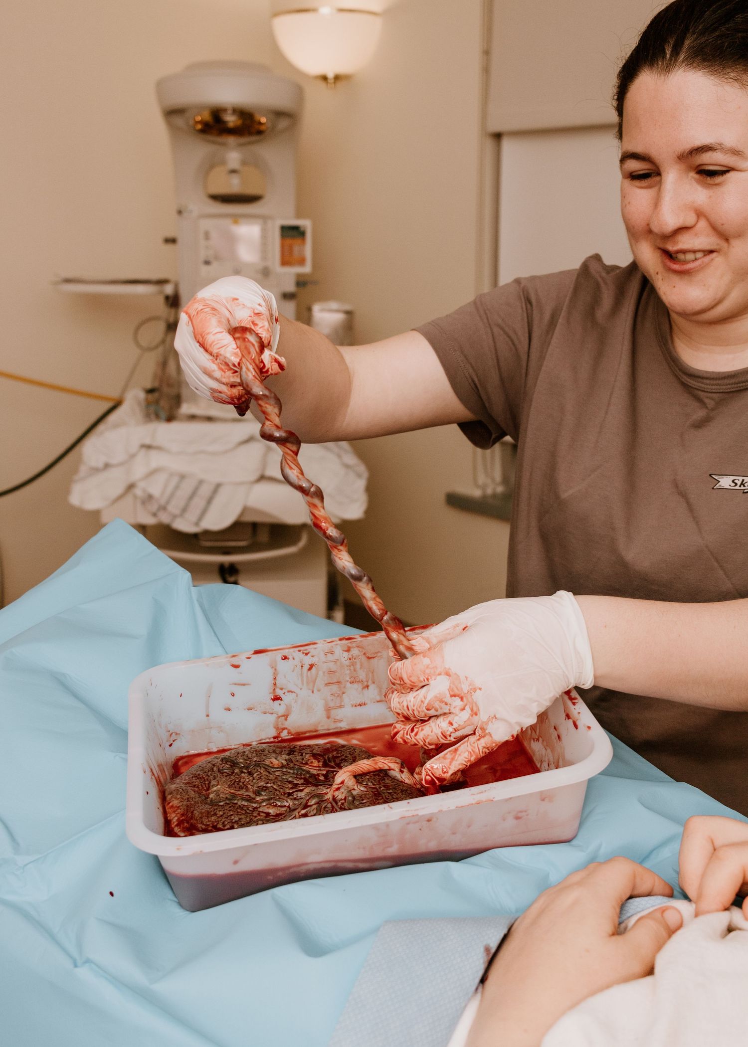 Healthcare worker handling medical equipment in a clinical setting.