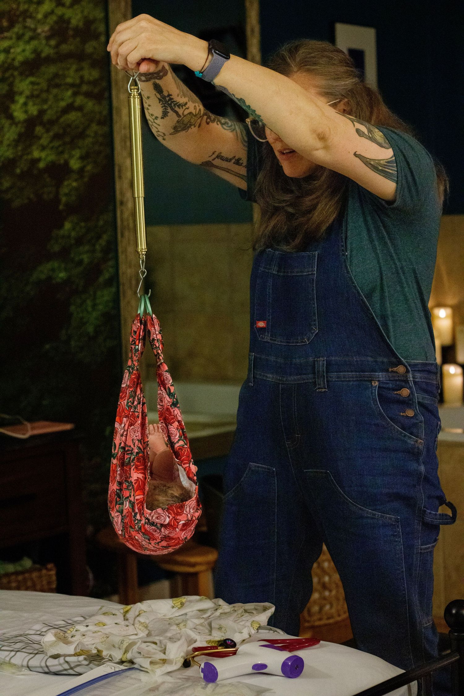 Person in denim overalls holding patterned fabric bag while organizing supplies.