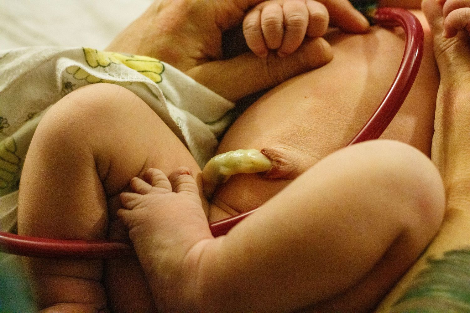 Close-up of baby's feet and legs while resting on soft bedding.
