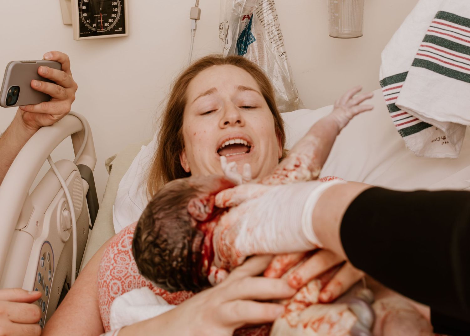 Raw emotional moment captured during childbirth in hospital setting.