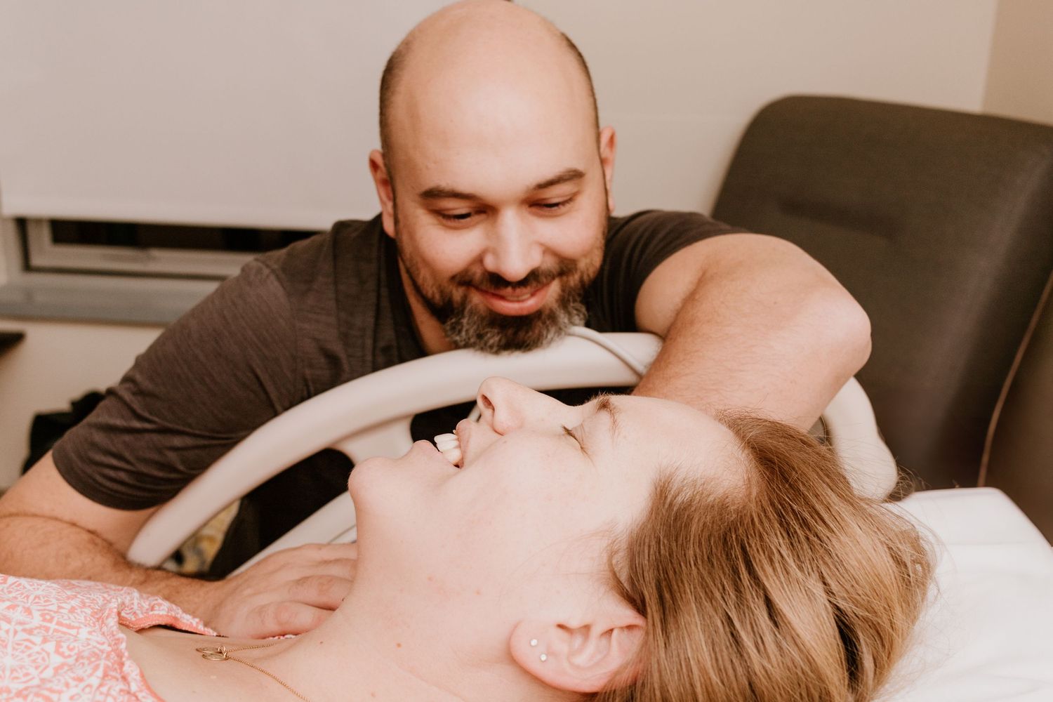 Candid moment during childbirth in hospital delivery room.