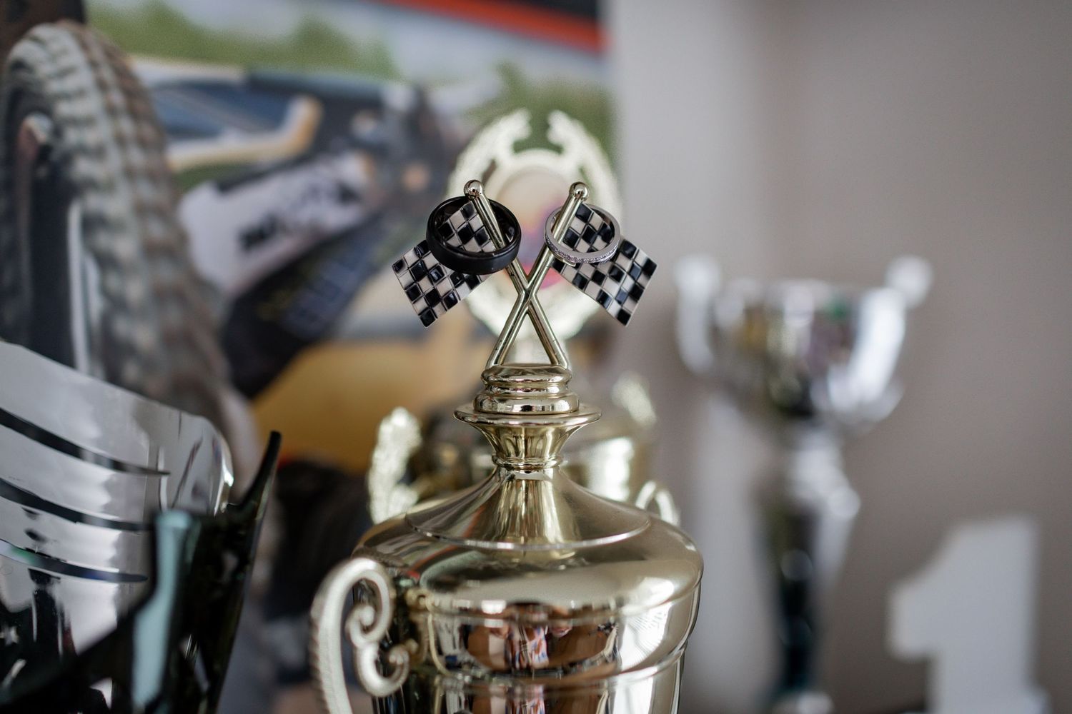 Racing trophy topped with crossed checkered flags displayed on metallic silver base.
