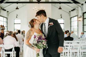 Bride and groom kiss at the end of ceremony aisle at wedding in Kansas City, Missouri.