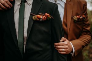 Couple stands together in suits at wedding in Missouri.