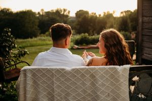 Couple sits together at sunset during an engagement photoshoot in Arkansas.