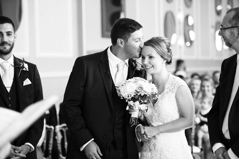 Intimate black and white wedding ceremony moment with couple sharing sweet glance.