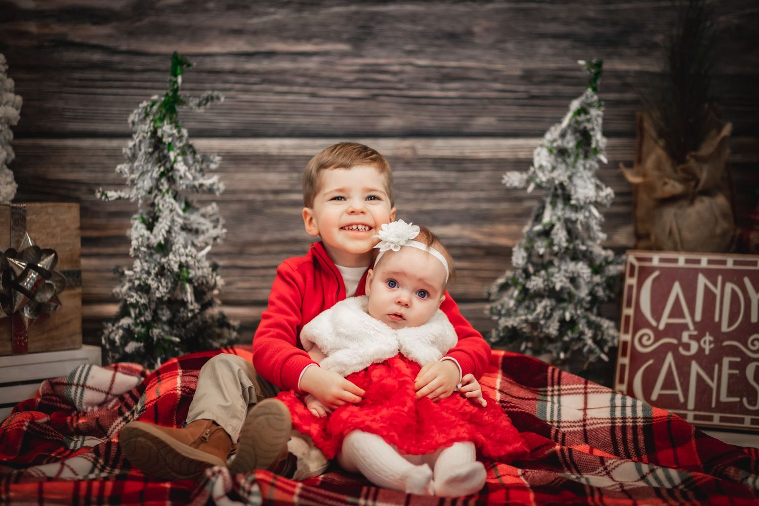 boy and girl holiday outfits hug for a perfect Christmas scene