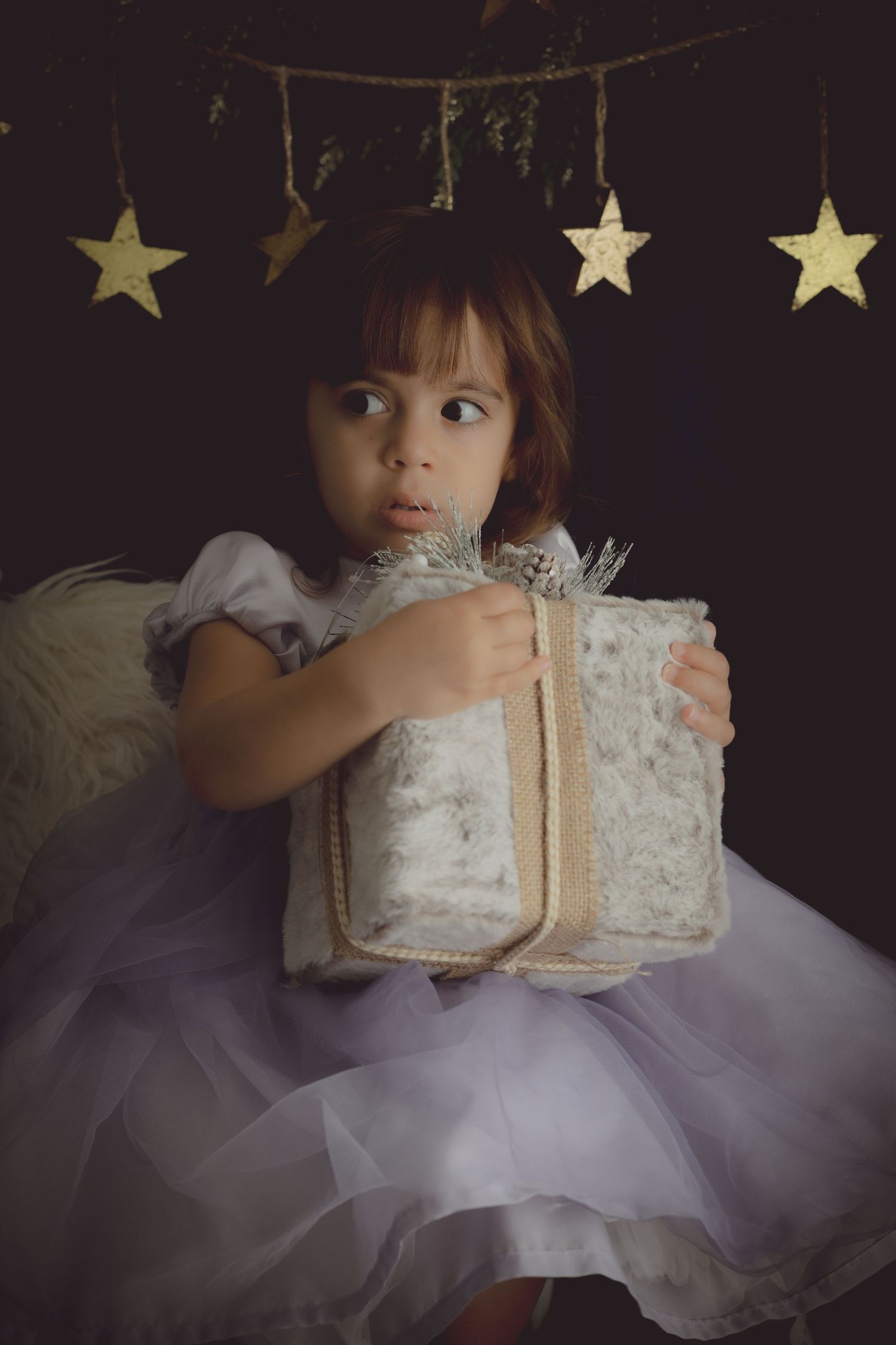 A little girl clings to her gift. This photo is smooth and dreamy