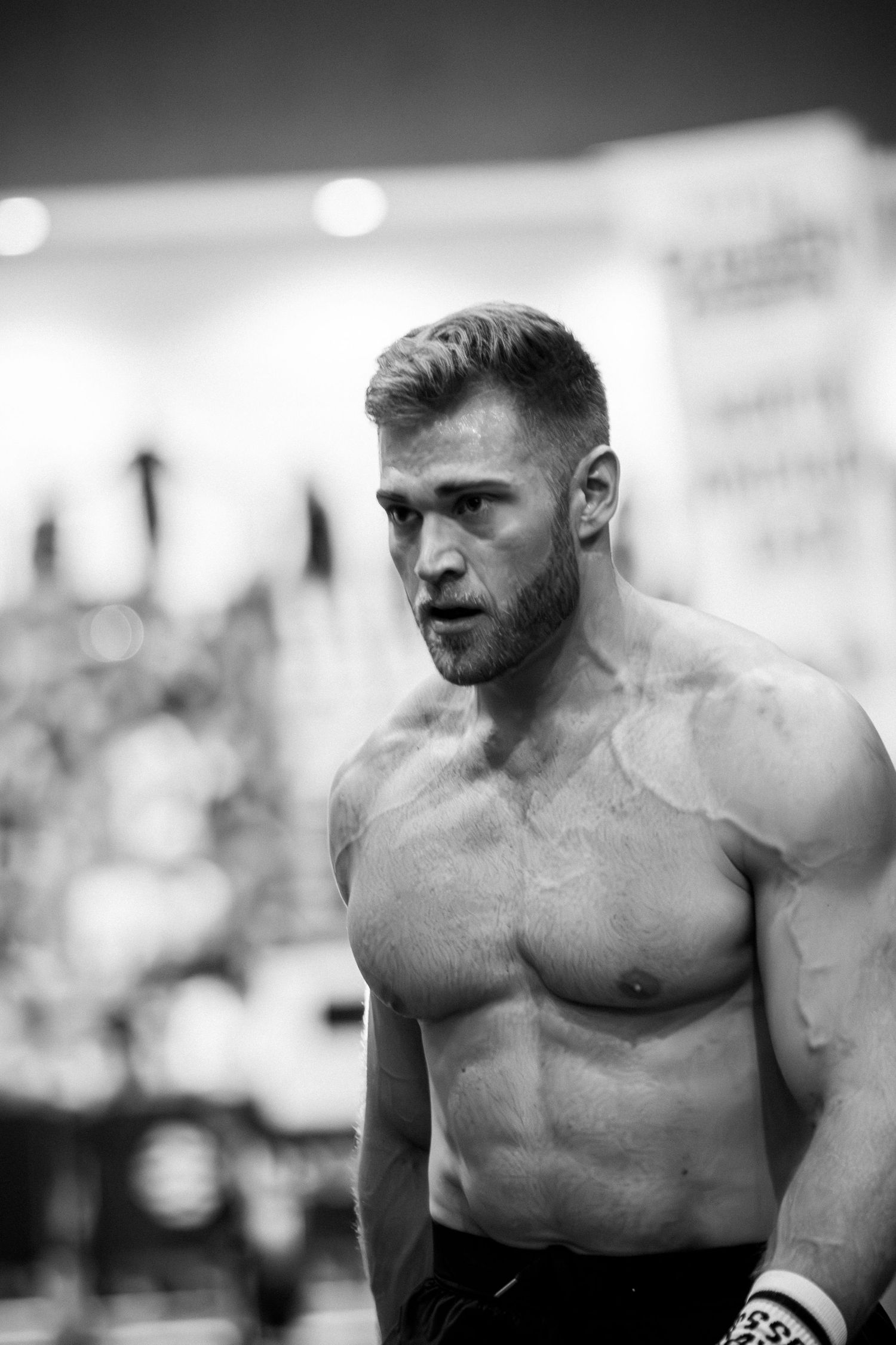 Black and white portrait of muscular athlete with intense expression.