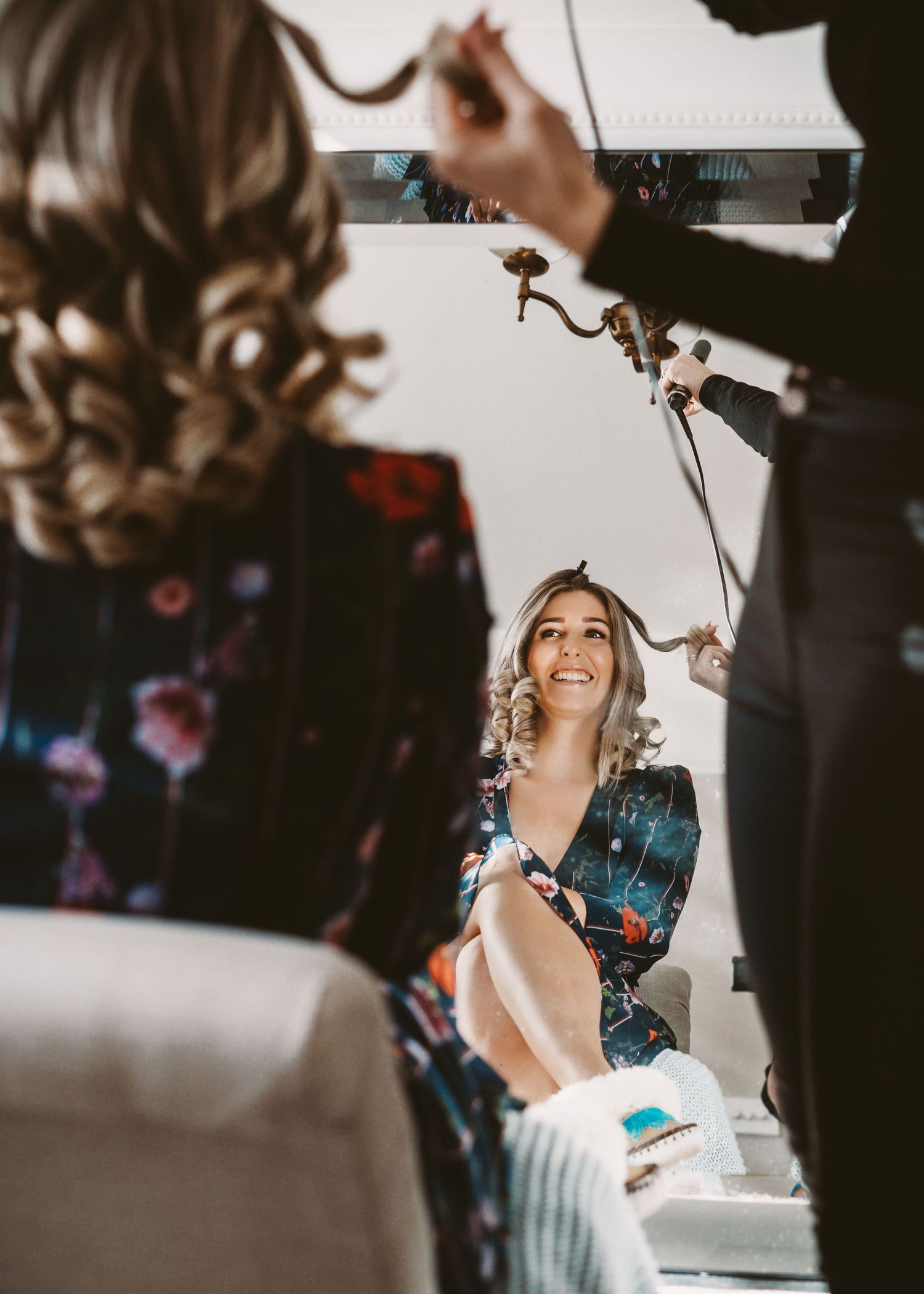 Behind the scenes of wedding day hair styling preparations in a dressing room.