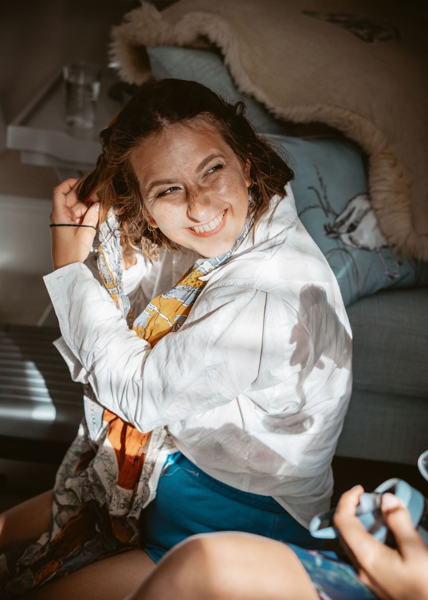 Cozy indoor portrait with dramatic lighting and warm white clothing.