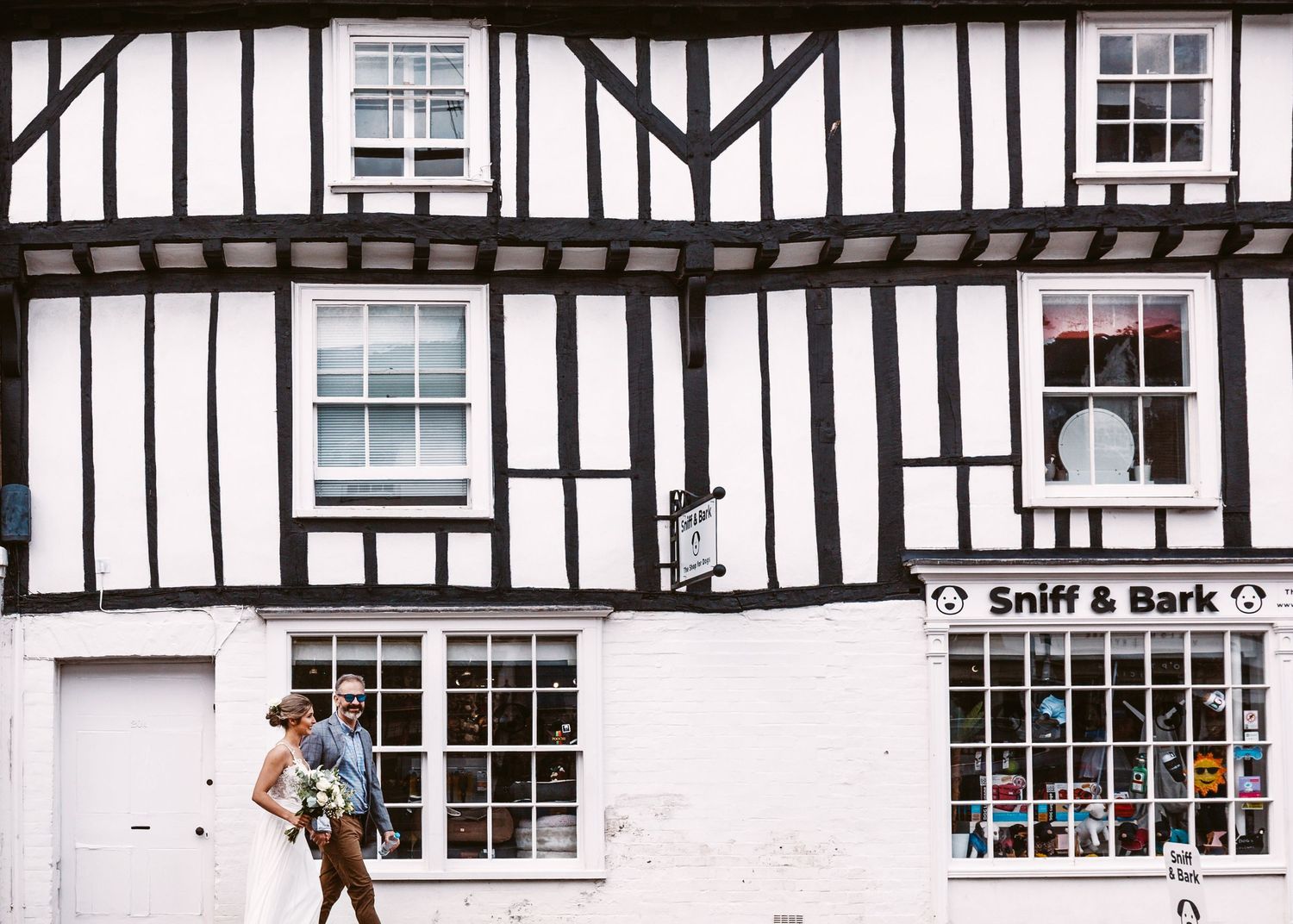 A classic Tudor-style building with black and white timber framing and a shop sign.