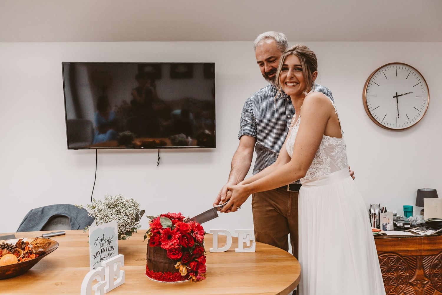 A celebratory cake-cutting moment at an indoor wedding reception.