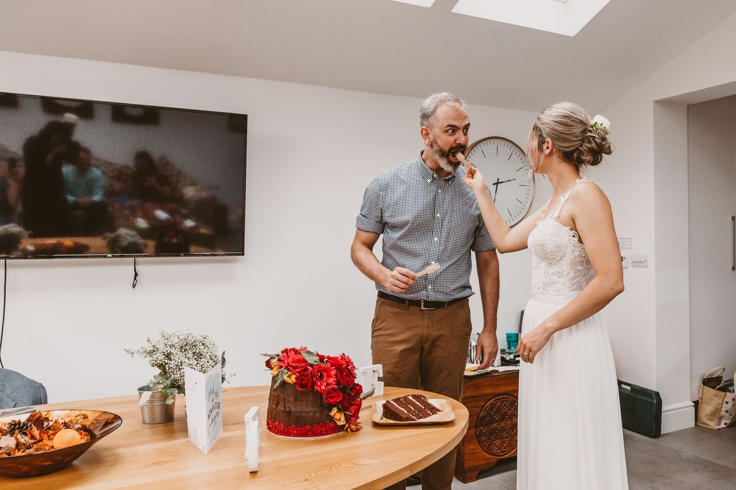 Candid moment between two people sharing cake at an intimate wedding celebration.