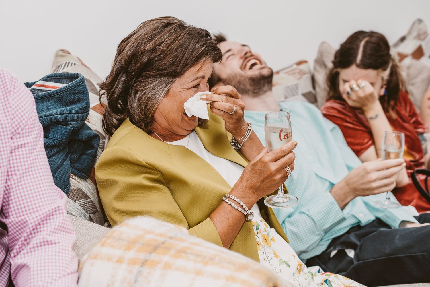 A group laughs together while sitting on comfortable seating during a celebration.