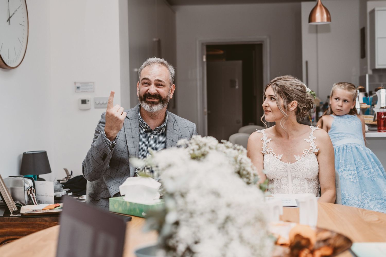 A joyous celebration moment captured at a dining table with floral decorations.