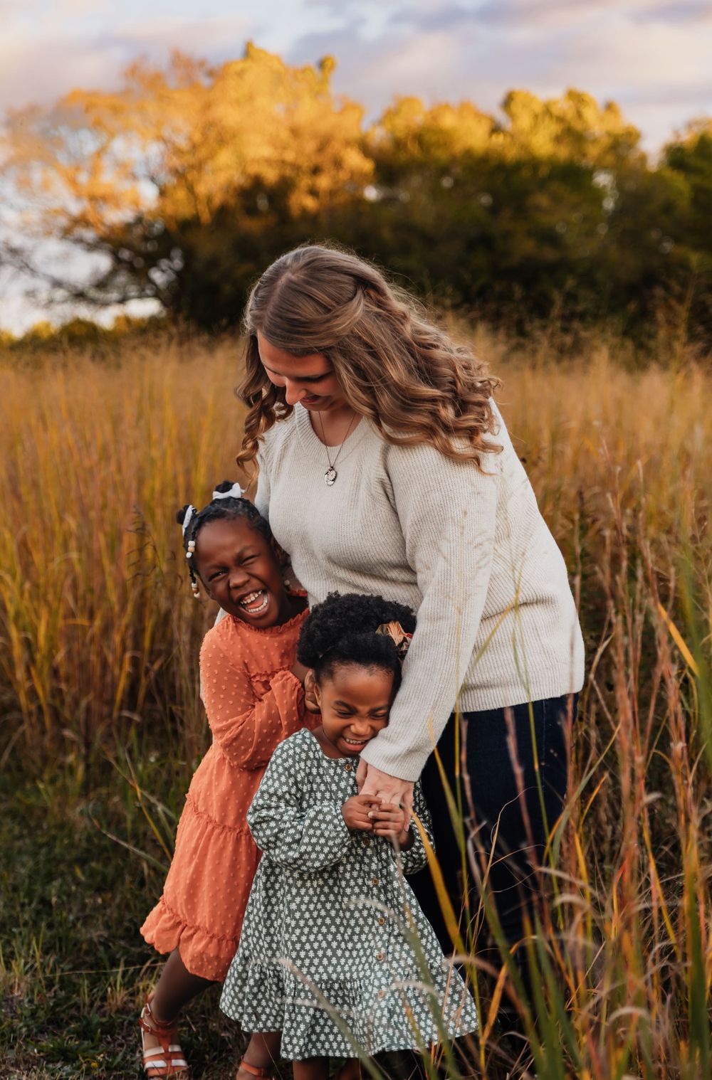 A heartwarming family moment captured in a golden field during sunset.