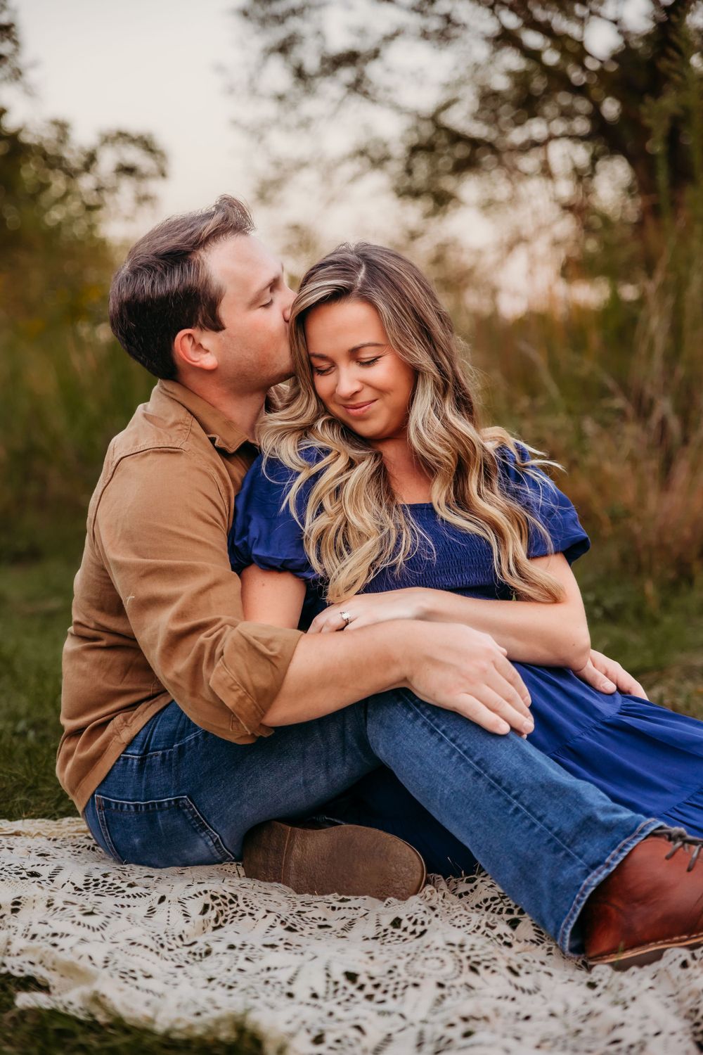 Couple relaxing together on rocky surface during outdoor photo session.