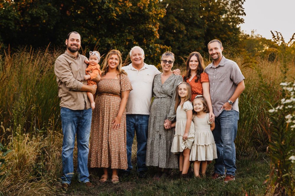 Extended family portrait session outdoors during sunset with natural fall colors.